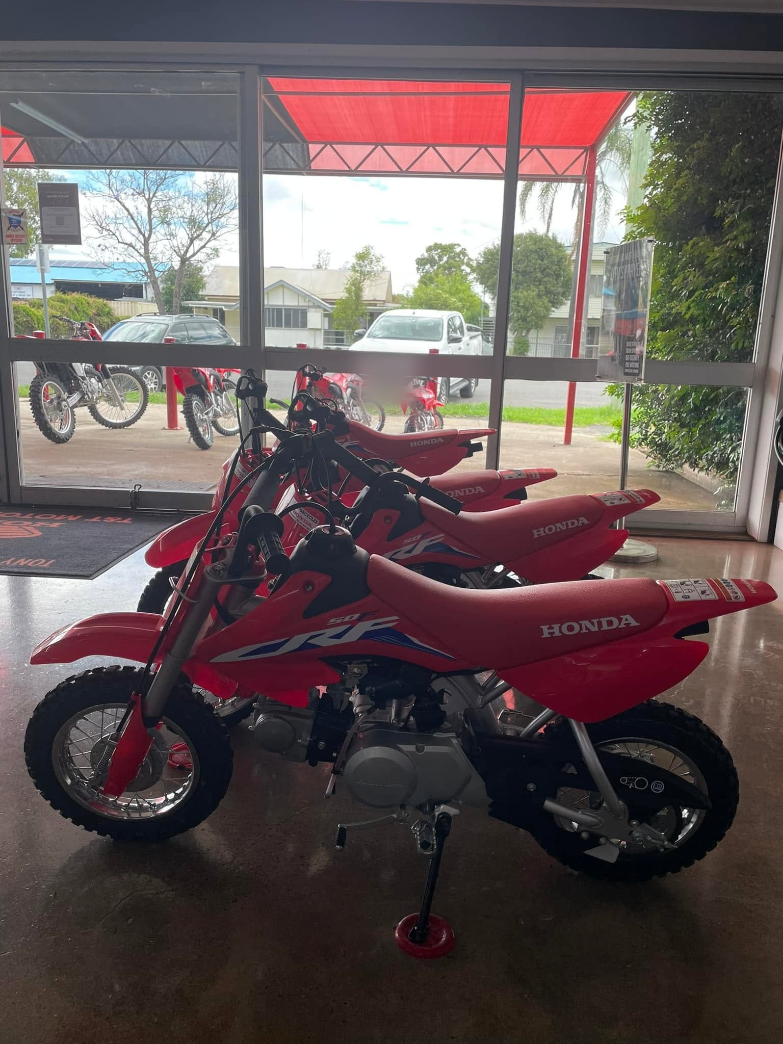 A row of red Honda trail bikes inside the T&T Motorcycles showroom