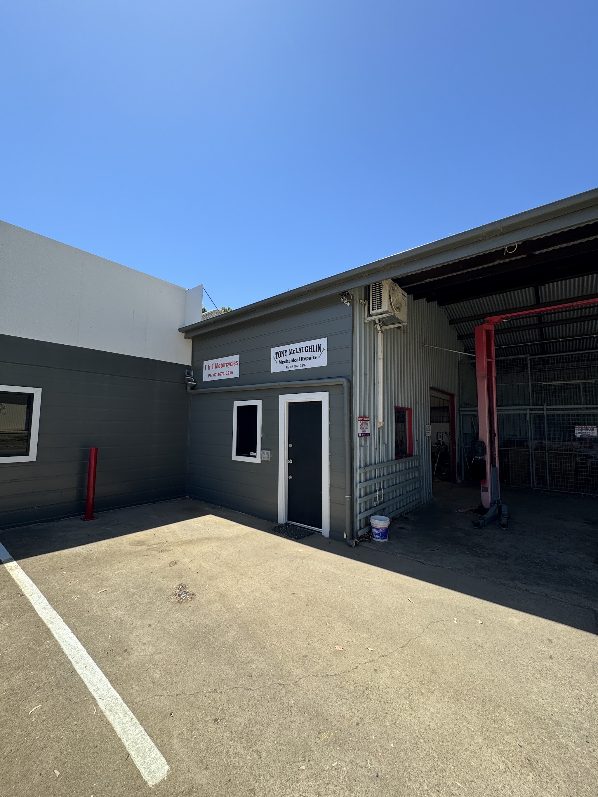 The two sign boards above the office door, T&T Motorcycles and Tony McLaughlin Mechanical Repairs